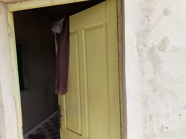 A yellow door with a maroon cloth hanging on it. - Quiet country house (saint louis)
