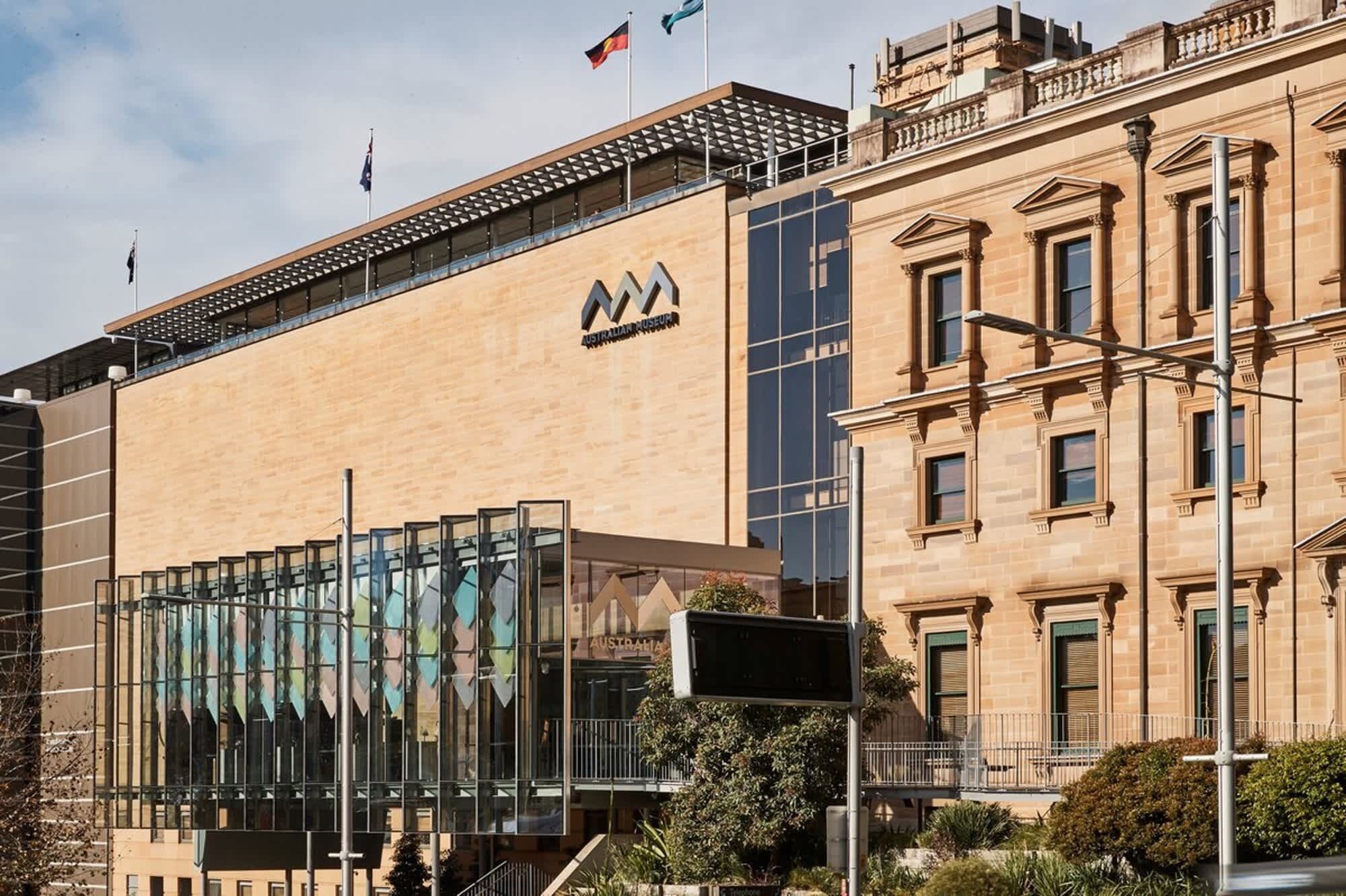 A building with a modern glass facade and a classical brick structure.