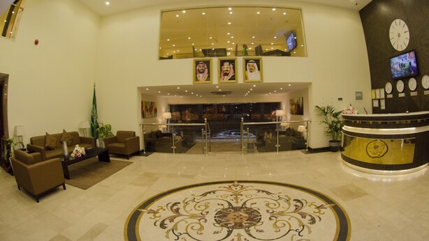 A lobby with a reception desk, seating area, and a decorative floor pattern. - Swiss Spirit Hotel & Suites Taif (Taif)