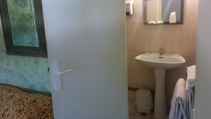 Une salle de bain équipée d’un lavabo, d’un miroir et d’un porte-serviettes.
