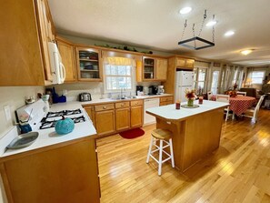 Efficient kitchen with gas stove, sink, and refrigerator, perfect for meal preparation and dining.