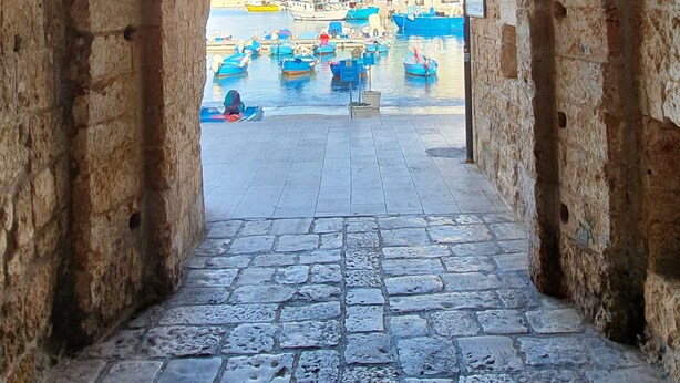 A stone pathway leading to a harbor with boats. - La Terrazza dell'Antico Gozzo (Monopoli)