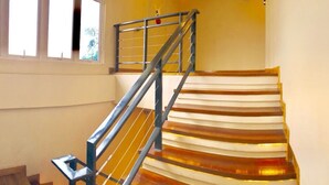A staircase with a metal railing and wooden steps. - Two Seasons Executive Suites (Zamboanga)