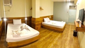 A hotel room with two beds, wooden headboards, a TV, and a shower area. - Two Seasons Executive Suites (Zamboanga)