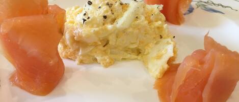A plate with scrambled eggs and smoked salmon.