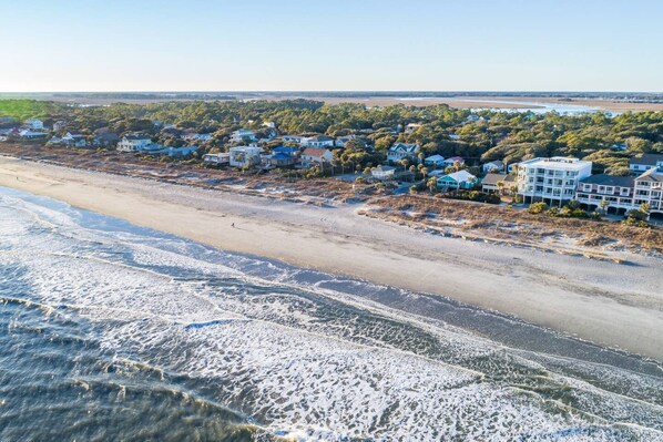 A coastal residential area with houses along the beach, a sandy shoreline, and waves approaching the shore. - High Tides| Walk to Beach & Center St| Rooftop Deck| Porches| Spacious Living| Seasonal Hot Tub (Folly Beach)
