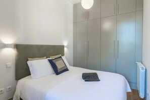 A bedroom with a bed, pillows, a headboard, and a wardrobe.