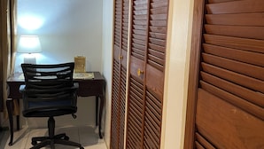 A room with a desk, chair, and a wooden wardrobe with louvered doors. - Widcombe House (Kingston)
