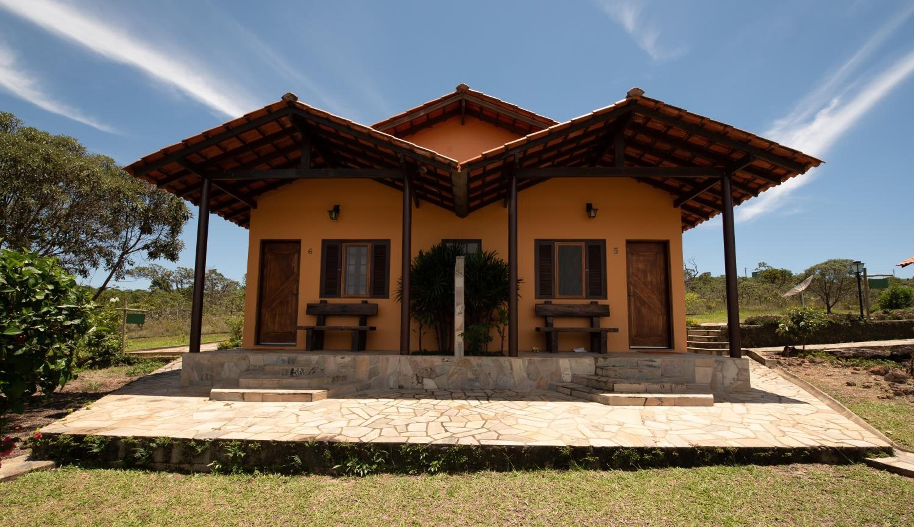 A two-story building with a tiled roof and a stone-paved entrance area.