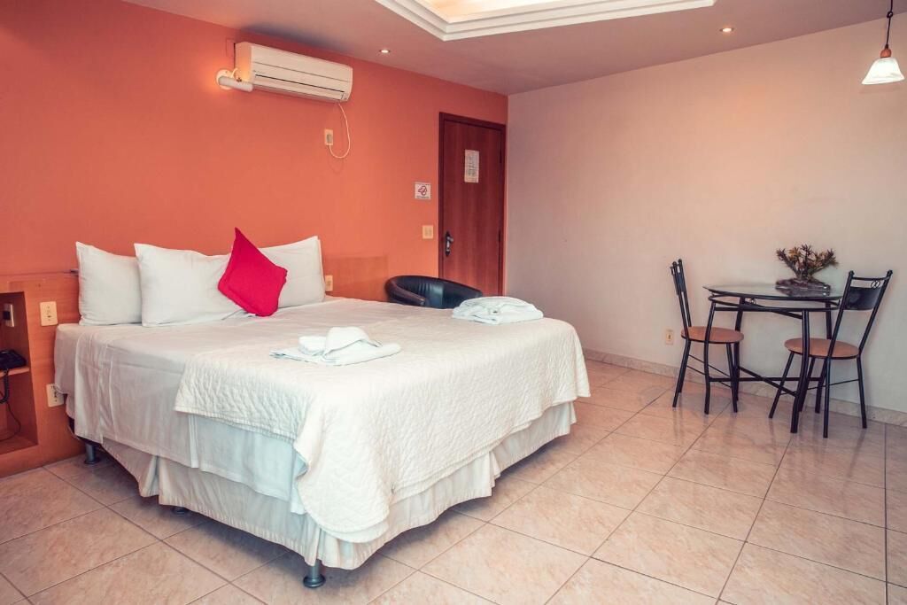 A hotel room with a bed, a desk, and a chair.
