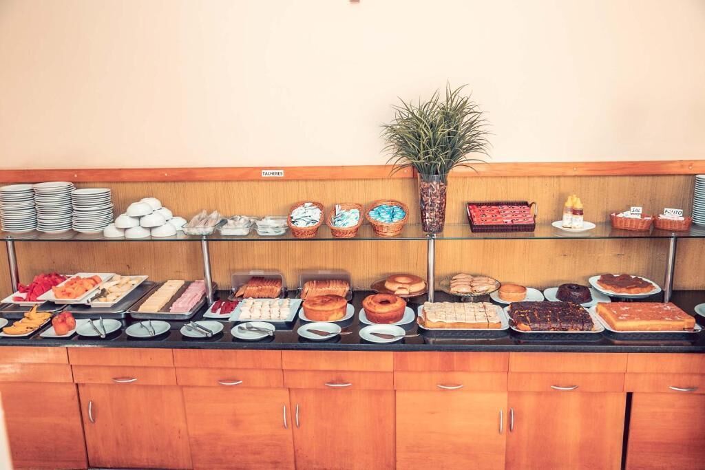 A buffet with various food items and a potted plant.