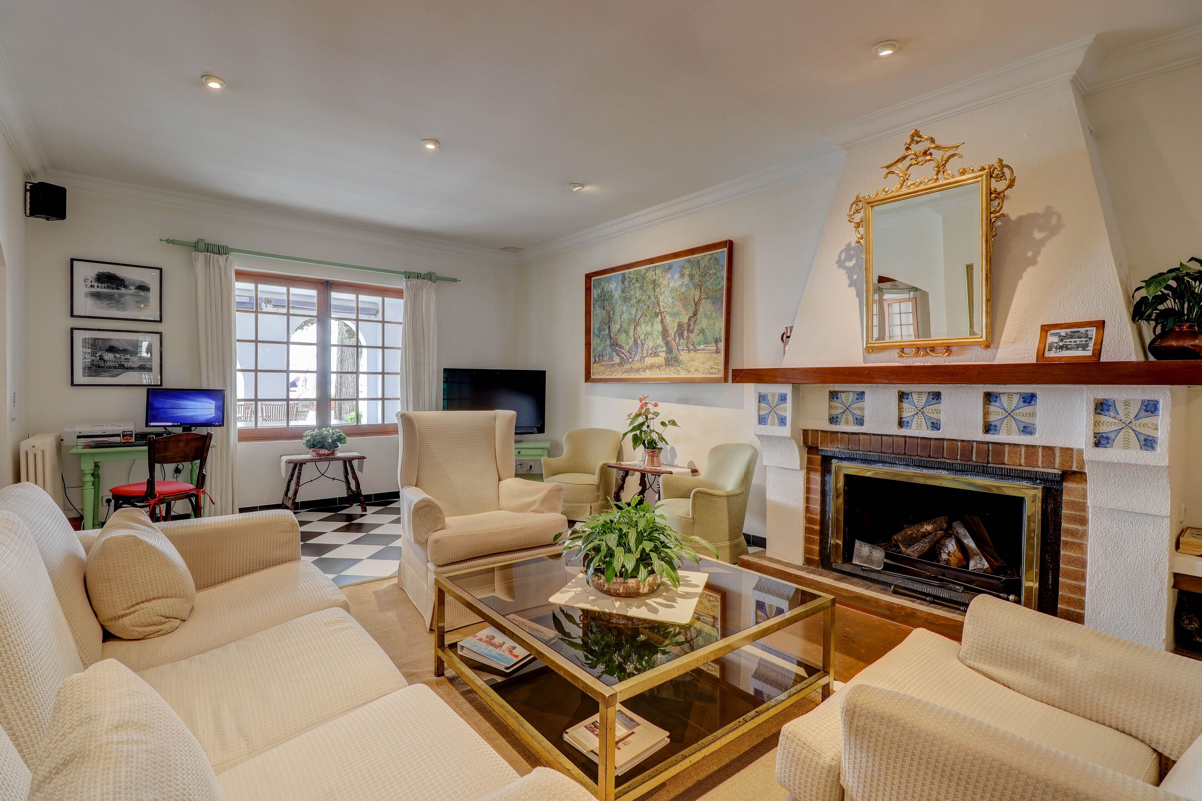 A living room with a fireplace, sofas, a coffee table, and a television.