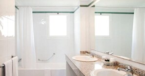 A bathroom with a bathtub, two sinks, and a large mirror. - Sis Pins (Pollença)