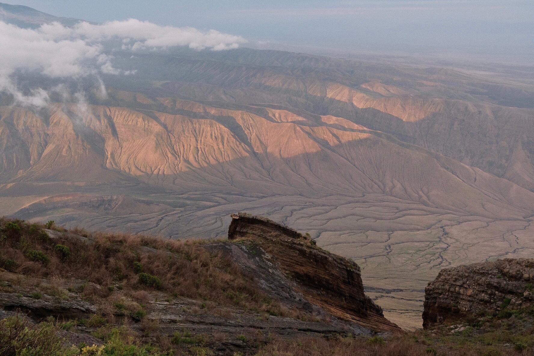 Un paisaje montañoso con una gran formación rocosa al frente.
