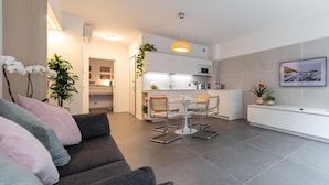 Een modern appartement met een zithoek, eetgedeelte en keuken.