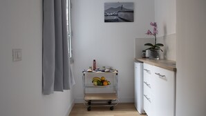 A kitchen with a fruit cart, a potted orchid, and a framed picture on the wall. - Vesuvio Blu Apartment in the center of Naples (Napoli)