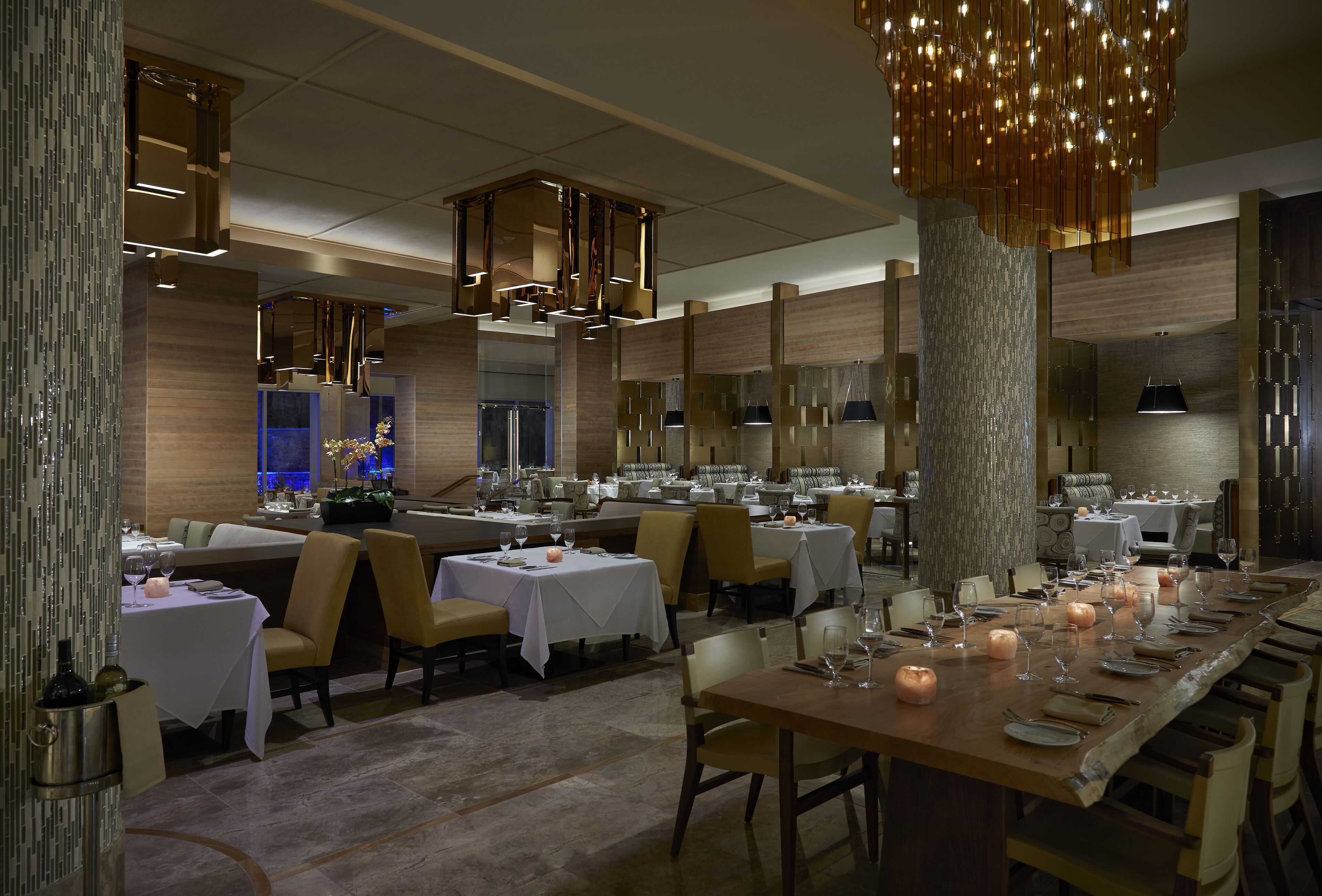 Un restaurante amplio con varias zonas de comedor, cada una con mesas dispuestas para los comensales.
