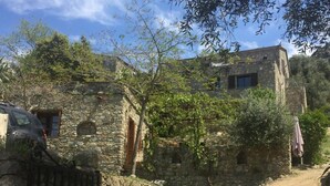 Ein rustikales Steinhaus mit einem Feldweg davor.