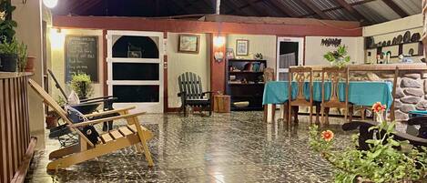 A rustic interior with a tiled floor, wooden furniture, and a variety of plants.
