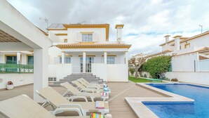 A poolside area with lounge chairs and a swimming pool.