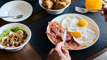 A breakfast setting with various dishes including eggs, muffins, and a cup of coffee.