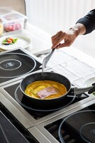 A person cooking an omelette on an induction stove.
