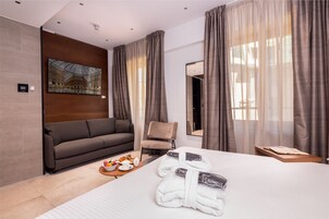 Een moderne hotelkamer met een groot bed, een bank, een stoel en een schilderij aan de muur.