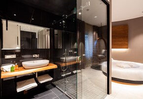 Een moderne badkamer met een groot wastafel, spiegel en douchehoek.