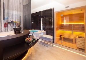A modern spa area with a reception desk, a massage table, and a sauna. - The Corner Duomo Hotel (Milan)
