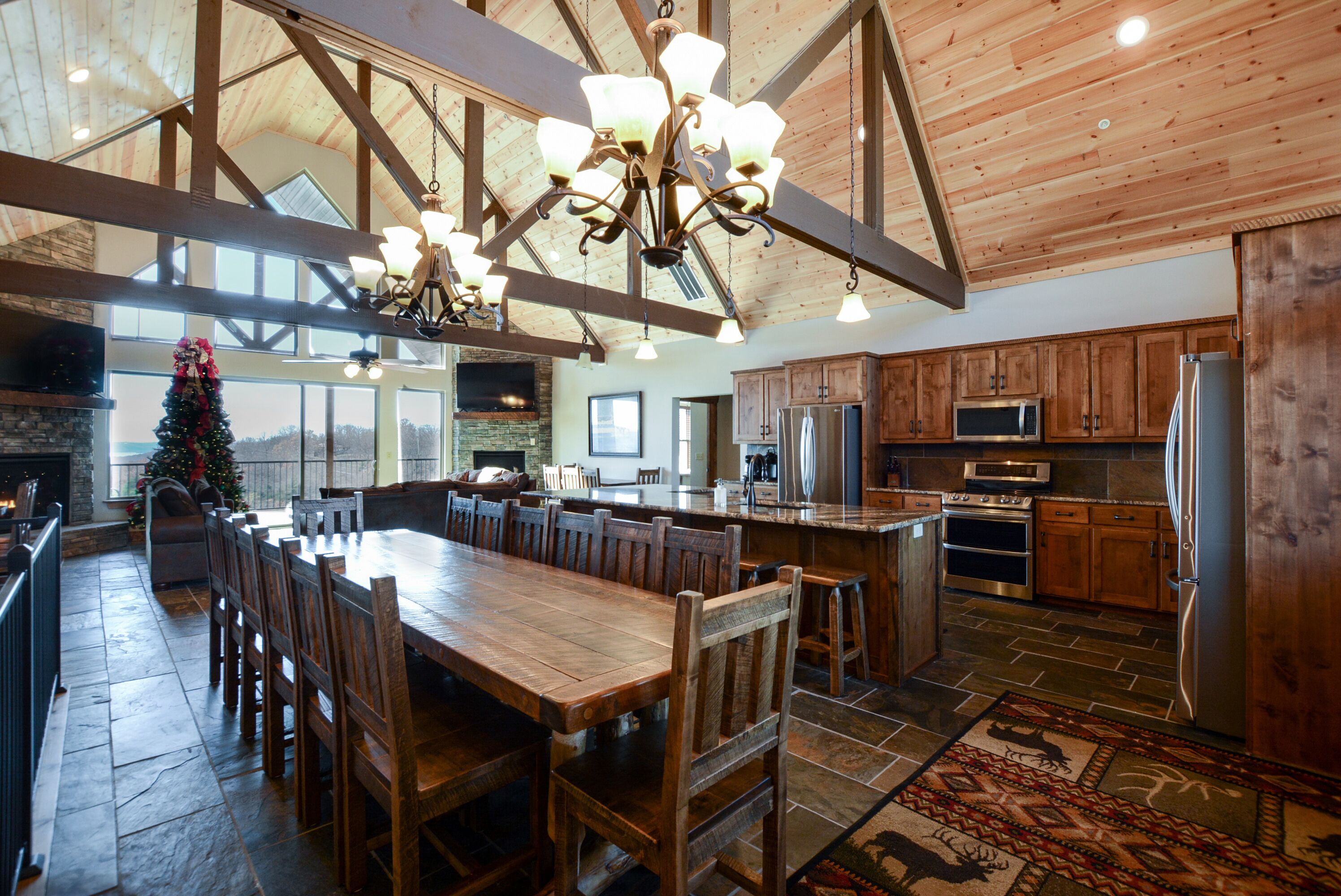 A spacious kitchen with wooden cabinets, a large island, and a stone floor.
