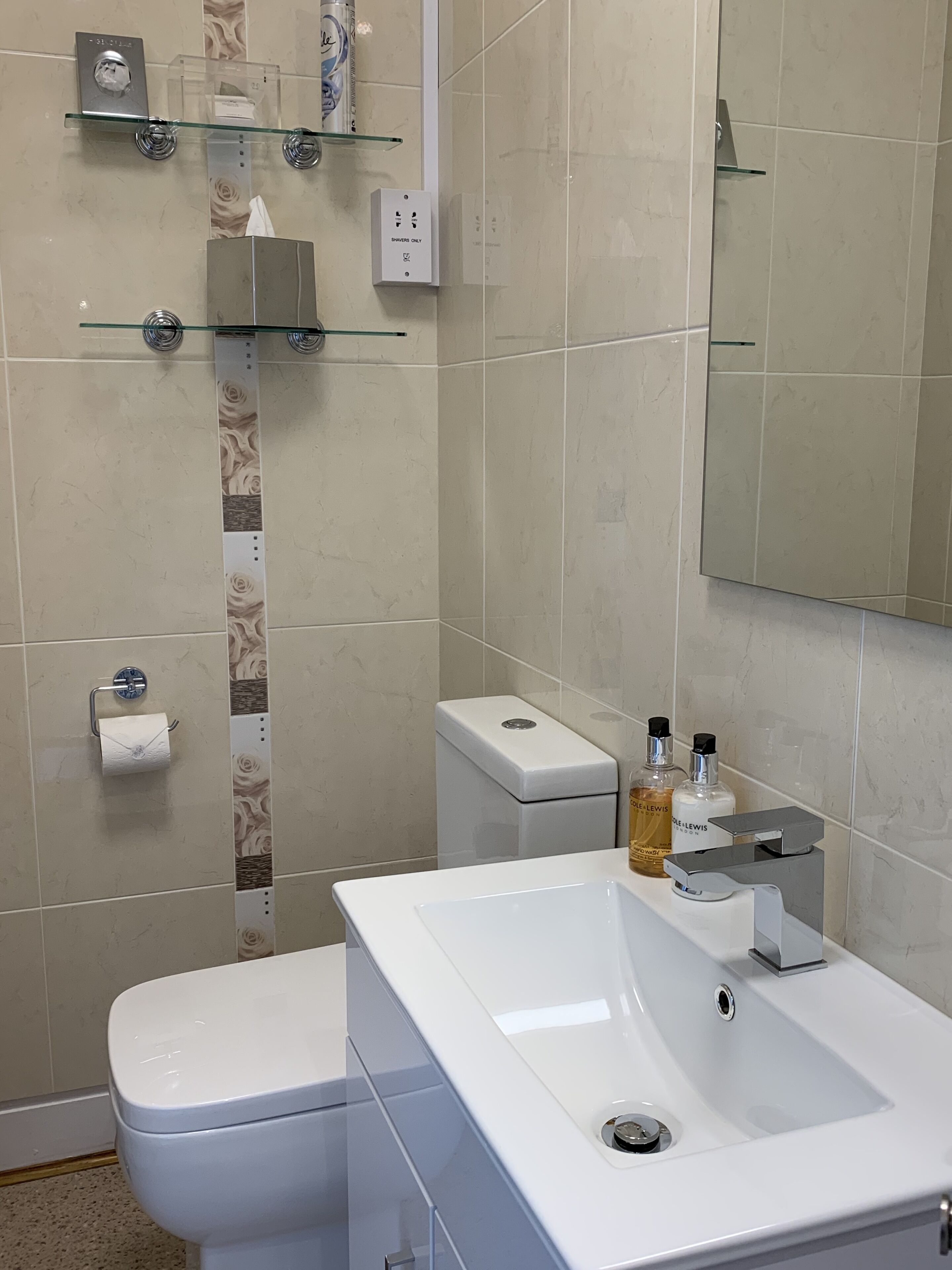 Un baño moderno con inodoro, lavamanos y zona de ducha.