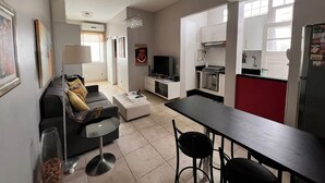 A modern apartment with a living room, dining area, kitchen, and a small balcony.