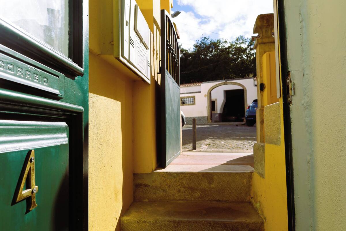 A narrow stairway leading to a door with a brass number plate.