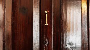 A wooden door with a brass number '1' handle.