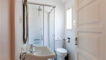 A bathroom with a sink, toilet, and shower.