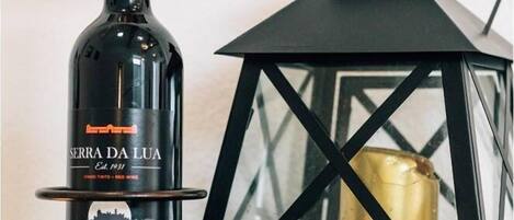 Una botella de vino Serra da Lua con un cartel de precio encima, colocada al lado de un farol negro.