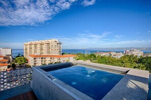 A rooftop pool with a clear view of the ocean and surrounding buildings. - Chic, Spacious Condo | Great Walkability, Pool, Gym, Rooftop Views (Puerto Vallarta)