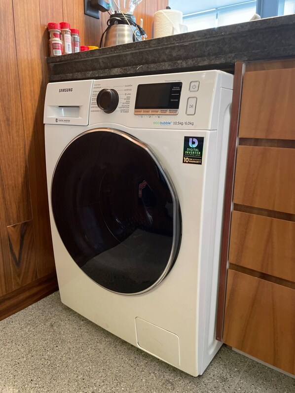 A Samsung digital inverter washing machine with a digital display and a 10-year warranty sticker.