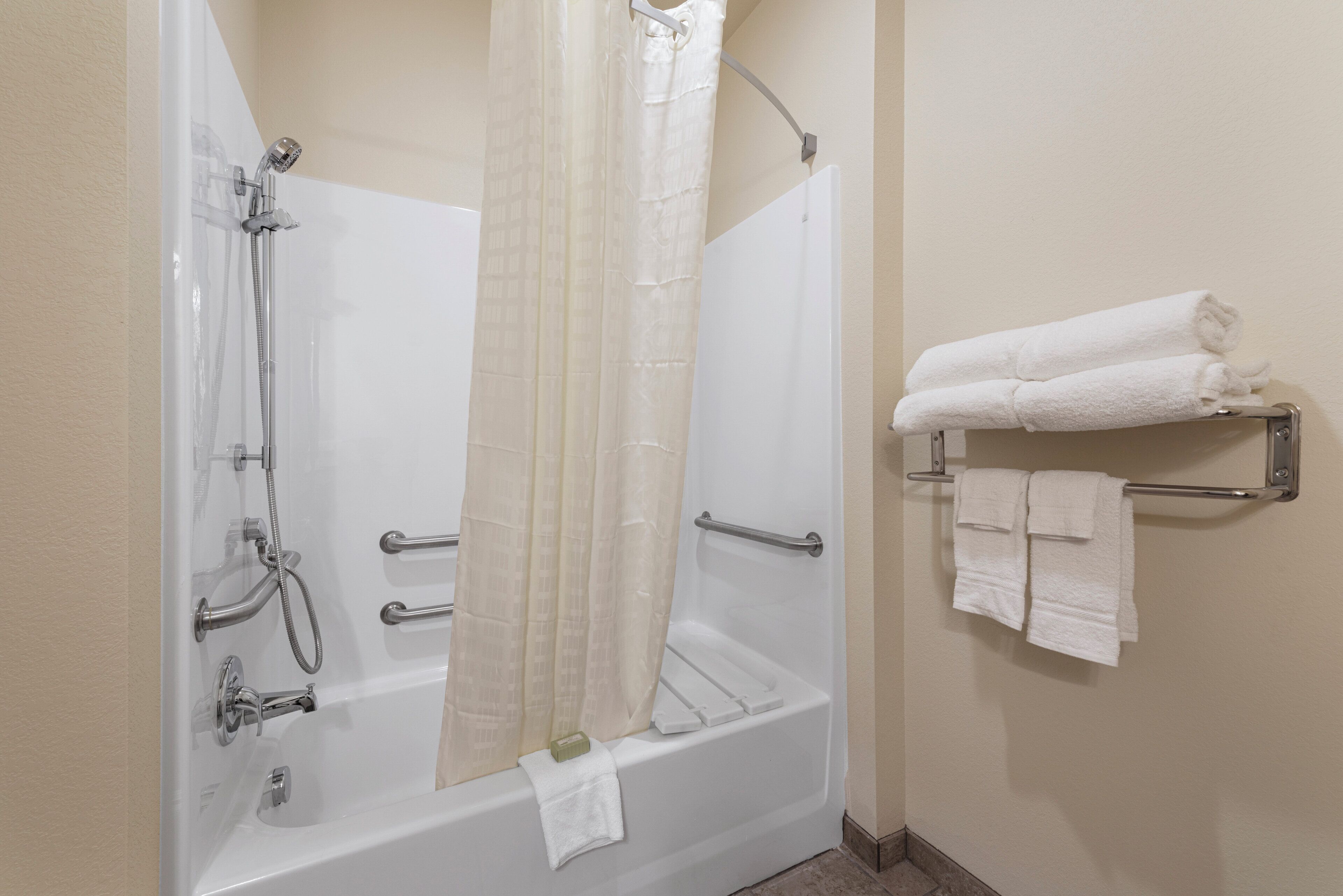 A bathroom with a bathtub, shower, and towel rack.