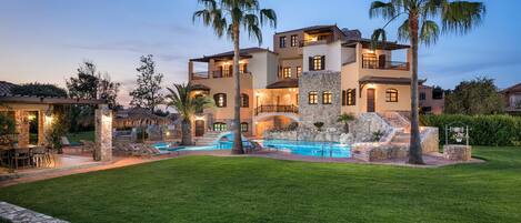 Vista frontal de la propiedad por la tarde o noche