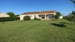 A single-story house with a tiled roof, a covered porch, and a well-maintained lawn. - Lavender Lodge, sleeps up to 6 people, (Étaules)
