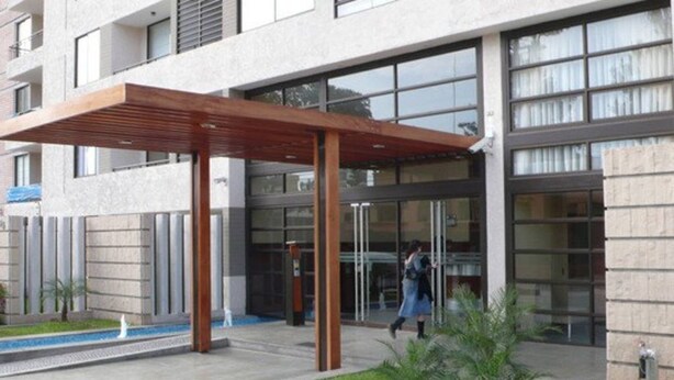 Un bâtiment moderne doté d’un porche, d’une pelouse bien entretenue et d’un chemin dégagé menant à l’entrée.