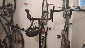 Un perchero de bicicleta instalado en la pared, con tres bicicletas aseguradas.