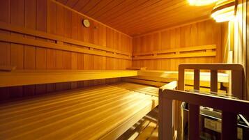 A sauna room with wooden benches and a visible heater.