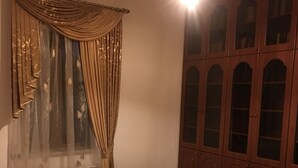 A room with a wooden cabinet, a radiator, and a table. - The luxurious private house in Yerevan, Armenia (Erebuni)