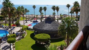 A resort with a pool, palm trees, and a view of the ocean. - Marina Pinacate A-421  1 BR w/ Sea View (Puerto Peñasco)