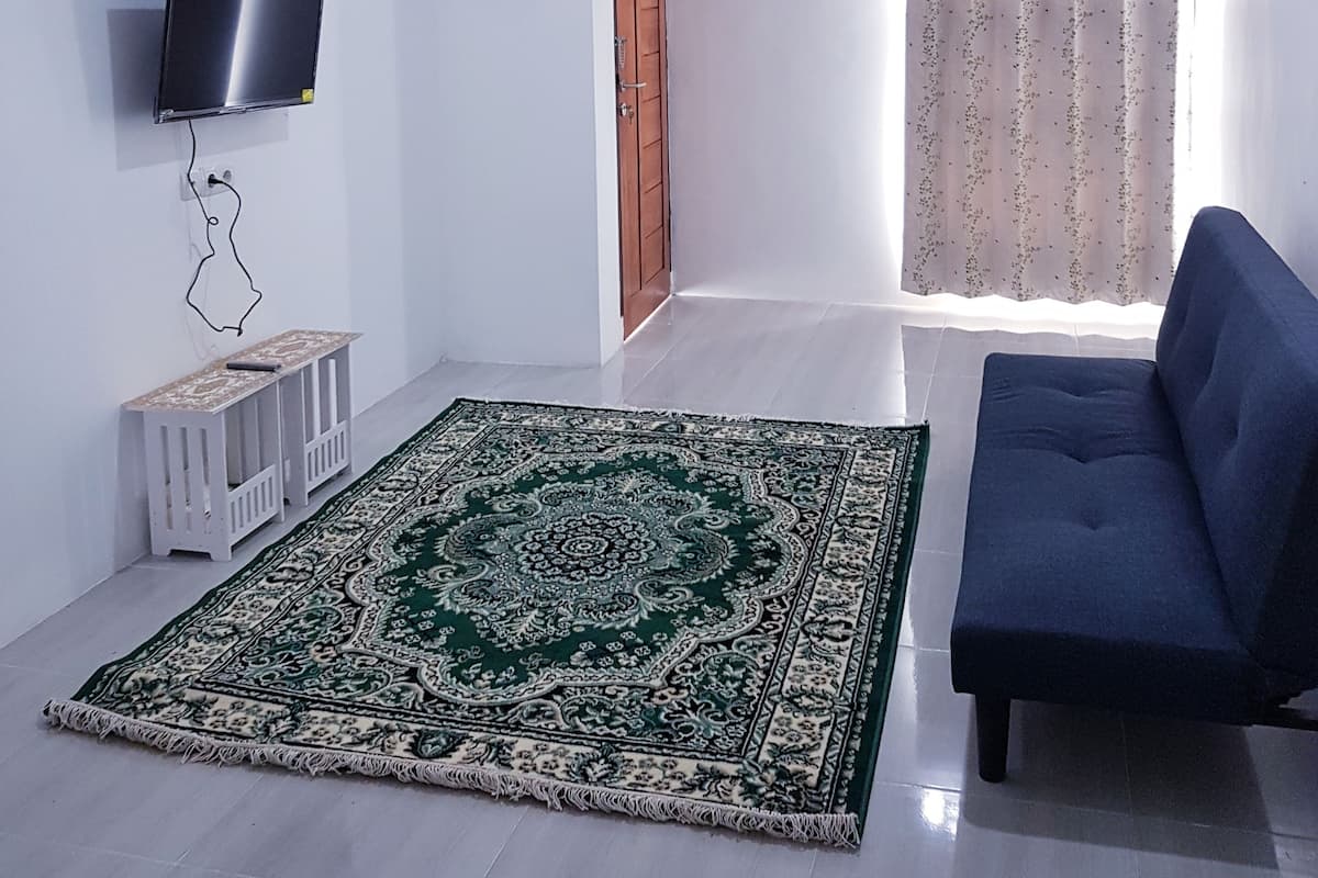 Habitación Deluxe | Área de sala de estar | Televisión de pantalla plana