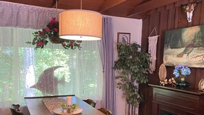 Zona pranzo con tavolo in legno, sedie, lampadario e camino.