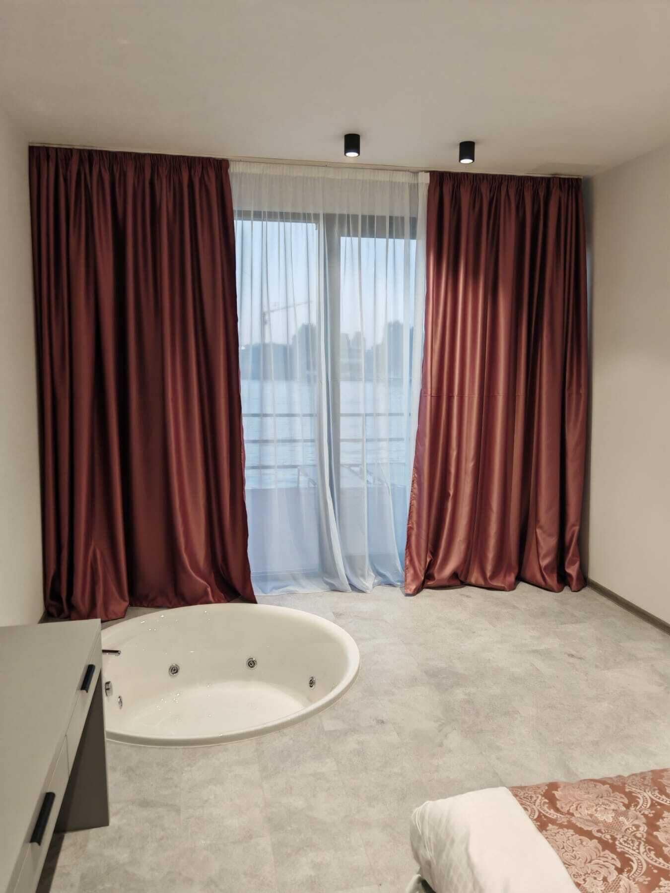 A modern bathroom with a bathtub, a shower, and a toilet.