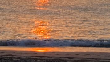 A sunset over a calm sea with gentle waves.